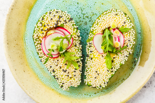 Cuadro en lienzo Beautiful avocado with sesame, arugula, radish and green onions