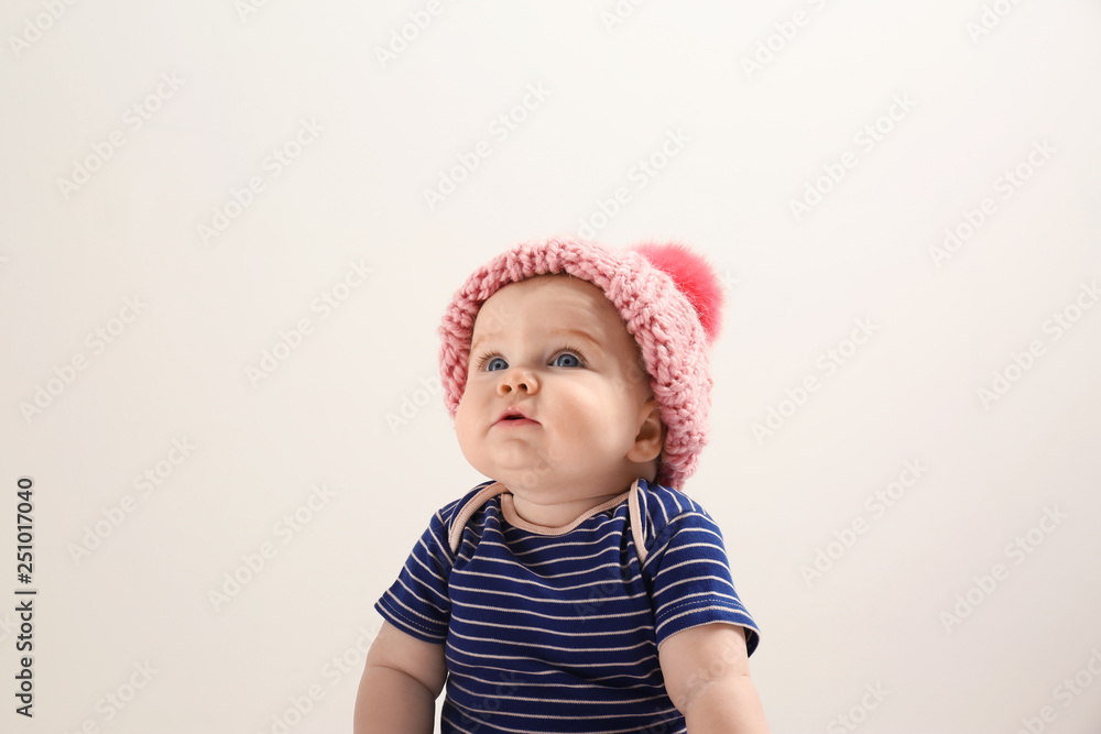 Little child in knitted hat on light background. Baby accessories Little child in knitted hat on light background. Baby accessories