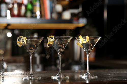 Glasses of lemon drop martini cocktail on bar counter. Space for text