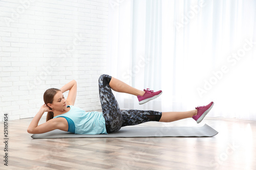 Young woman doing fitness exercises at home