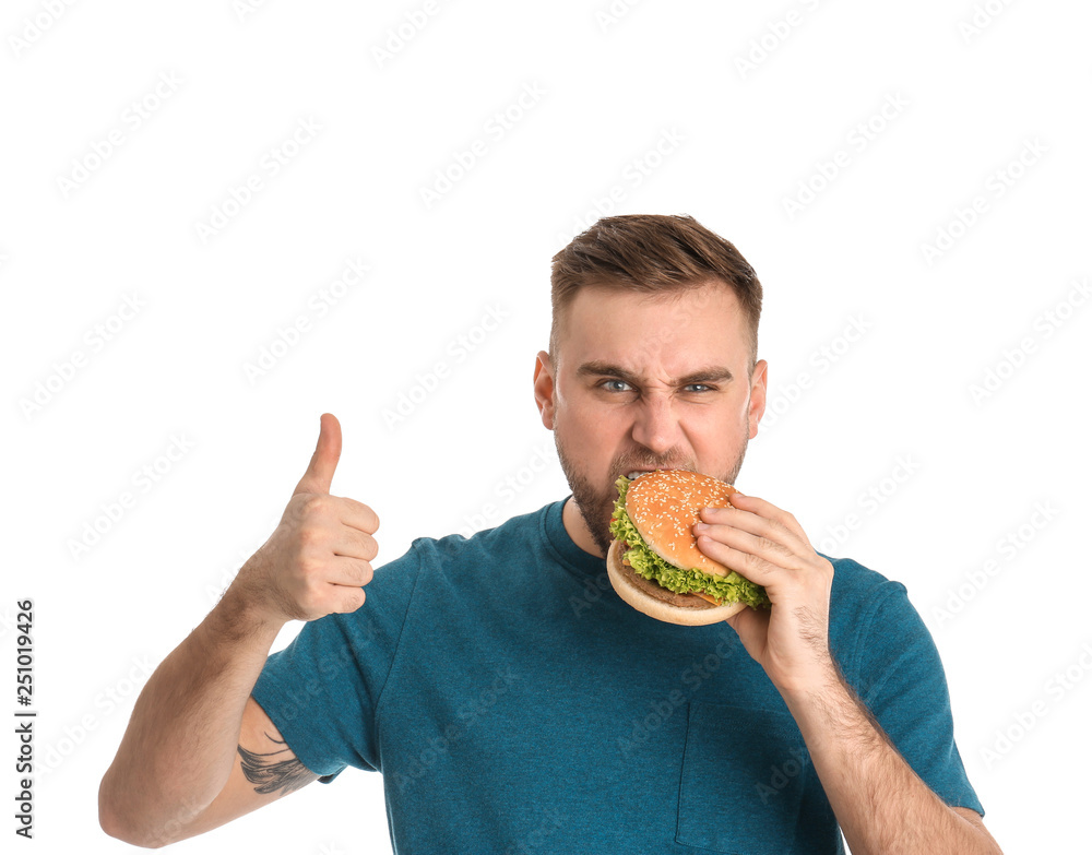 Young man eating tasty burger on white background Young man eating tasty burger on white background