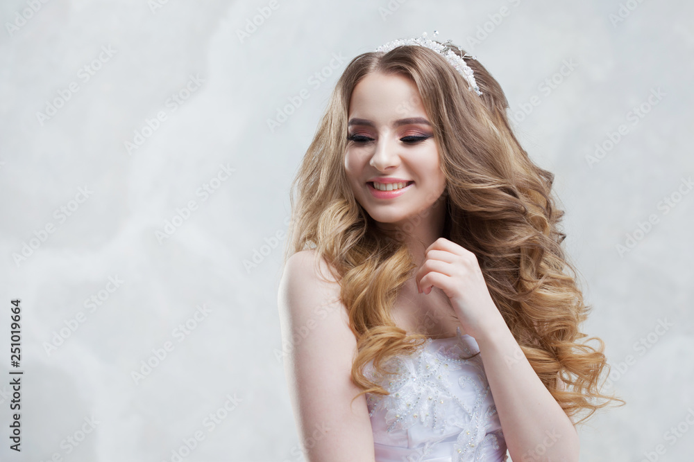 Beautiful young bride with lush curls, looking at something on the left. Wedding fashion Beautiful young bride with lush curls, looking at something on the left. Wedding fashion