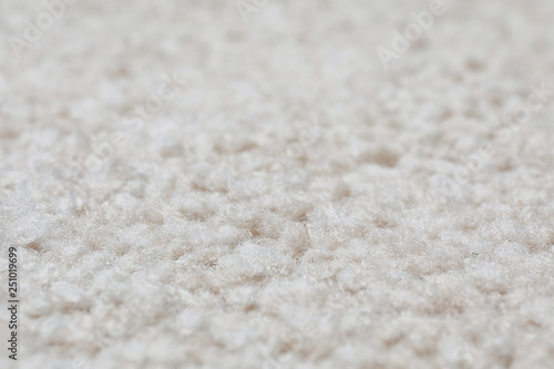 Fuzzy beige carpet texture as background, closeup