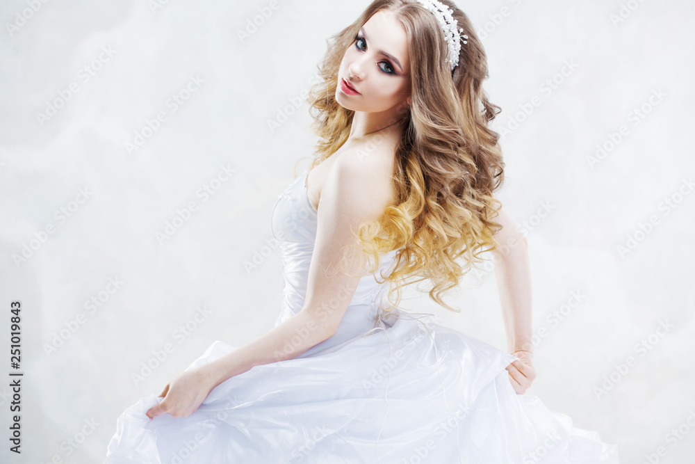 Charming young bride with luxury hairstyle. Beautiful woman in wedding dress. Hairstyle with fluffy curls. Charming young bride with luxury hairstyle. Beautiful woman in wedding dress. Hairstyle with fluffy curls.