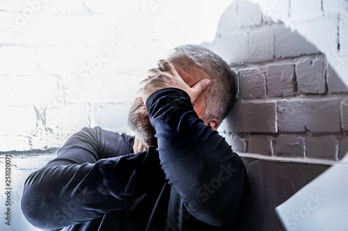 a desperate man holds his head with his hands photo