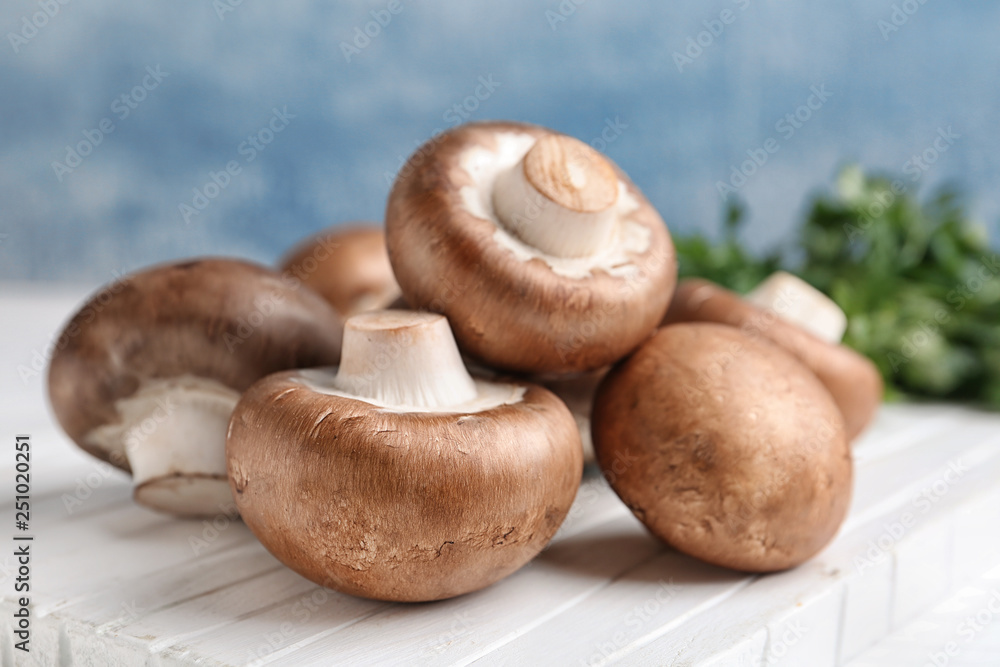 Fresh champignon mushrooms on wooden board, closeup Fresh champignon mushrooms on wooden board, closeup