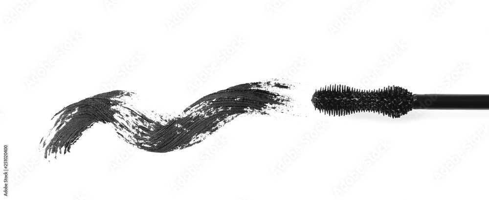 Applicator and black mascara smear for eyelashes on white background, top view Applicator and black mascara smear for eyelashes on white background, top view