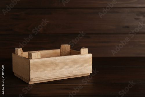 Empty crate on table against wooden background. Space for text