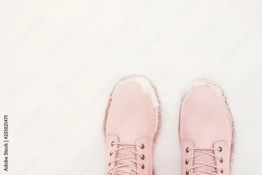 Female legs in pink boots in the snow Female legs in pink boots in the snow
