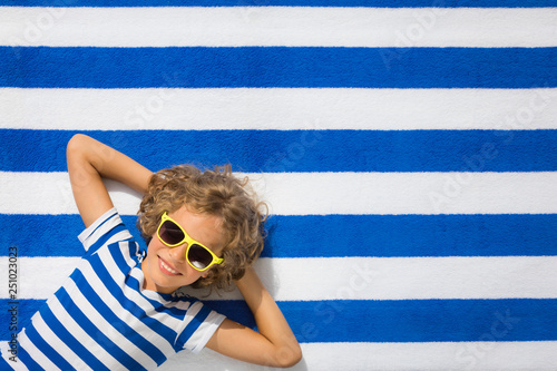 Top view portrait of child on striped beach towel
