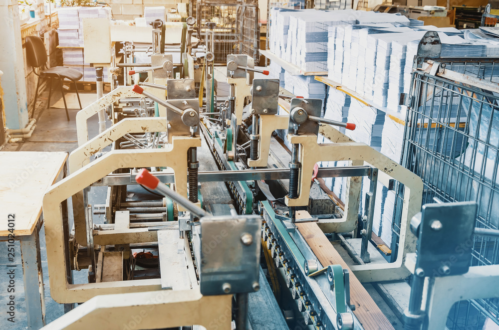 Machine for stitching sheets of paper in the printing. Magazine, brochure, book. Production of printed products. Vintage technology Machine for stitching sheets of paper in the printing. Magazine, brochure, book. Production of printed products. Vintage technology