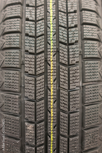 Close-up winter tire tread. Textured tire tread. Part of brand new modern winter car tire. vertical photo