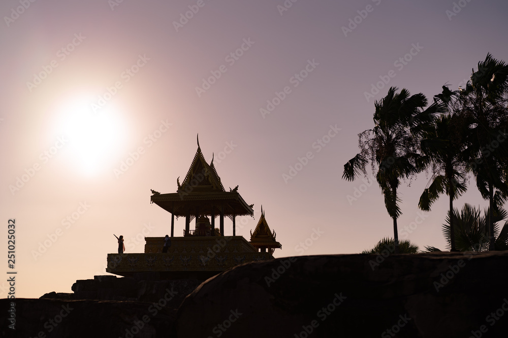 Ancient Asian Buddhist Temple with Dreaming Girl on Sunset in the Sun Shadow. Beautiful Scenic Landscape.