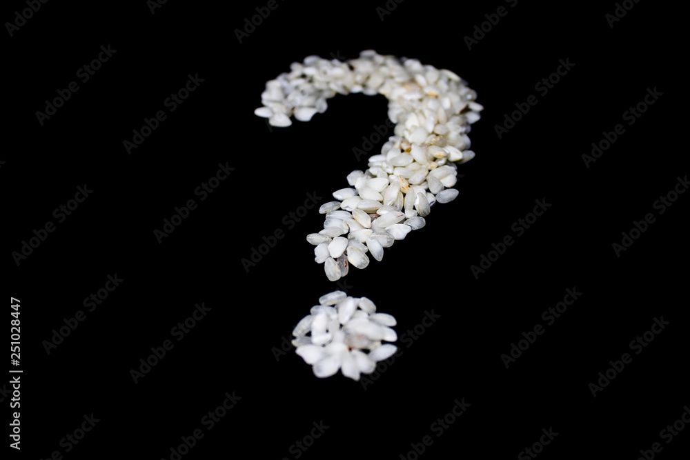 The question mark made from rice grain on the black background - Image