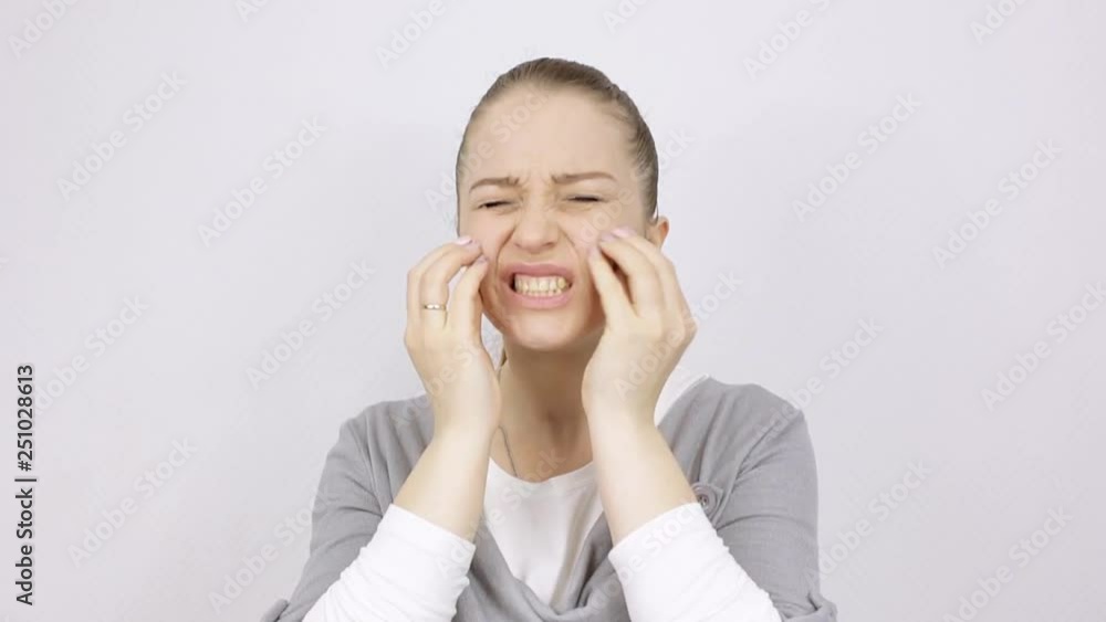 woman looks critically at the skin on her face in the mirror woman looks critically at the skin on her face in the mirror