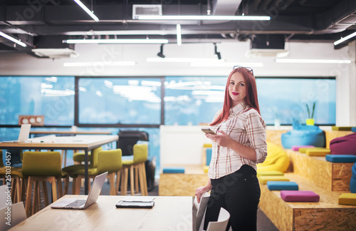 redhead businesswoman using mobile phone at office
