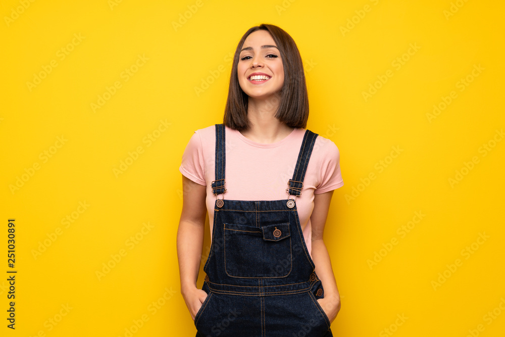Young woman over yellow wall smiling a lot Young woman over yellow wall smiling a lot