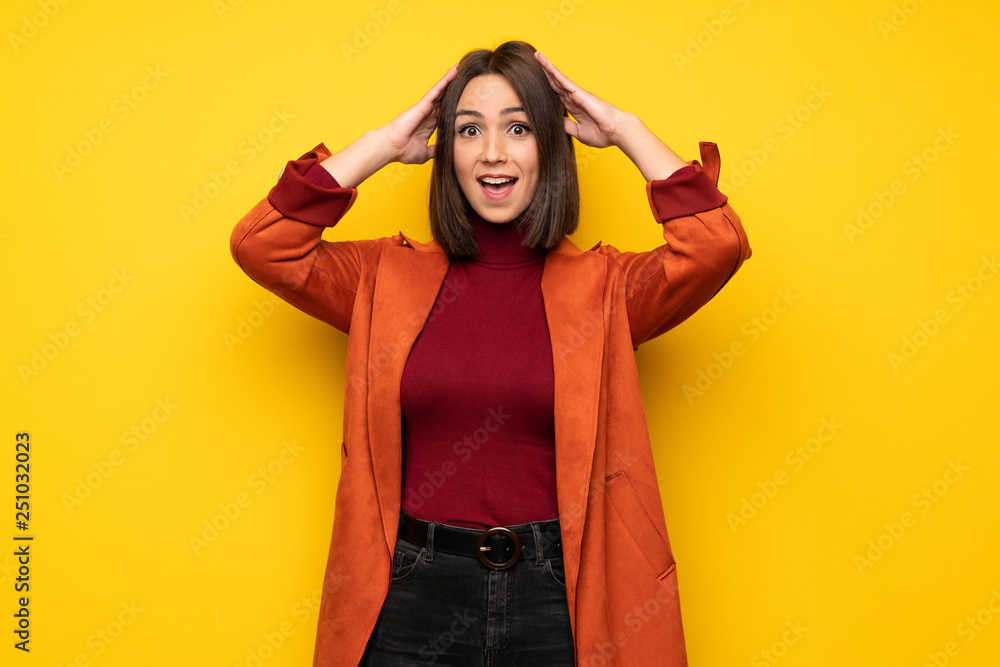 Young woman with coat with surprise and shocked facial expression Young woman with coat with surprise and shocked facial expression