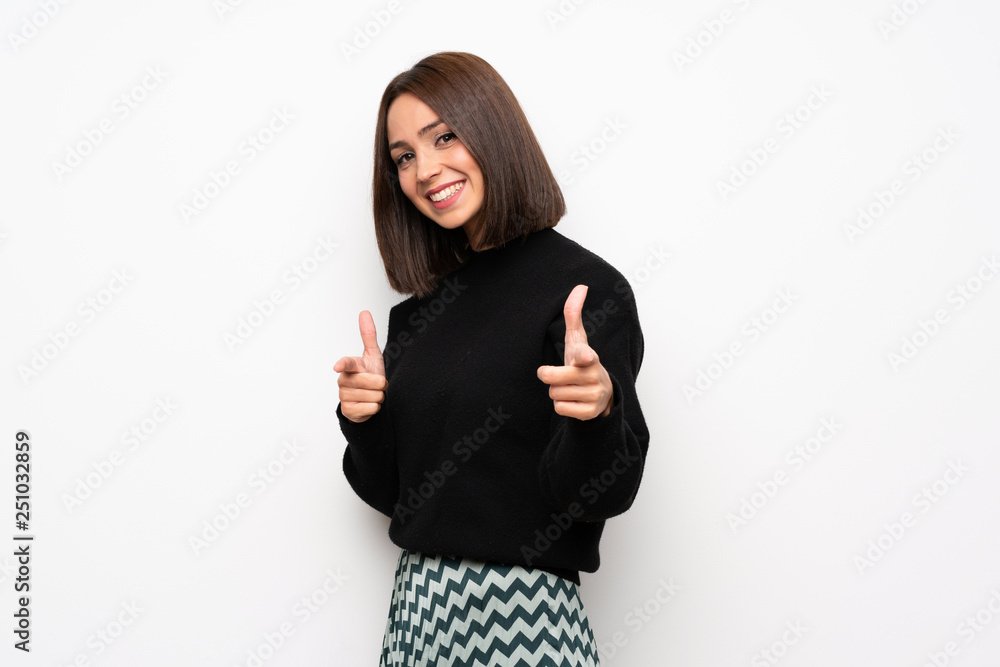 Young woman over white wall pointing to the front and smiling Young woman over white wall pointing to the front and smiling