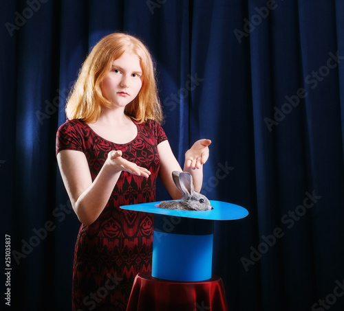 girl shows focus with a rabbit in a hat