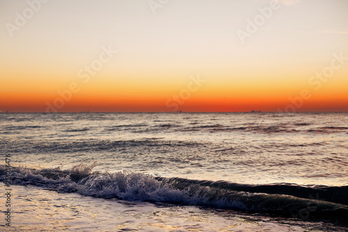 Beautiful view of sunrise in sea. Close Up of waves and beach at sea and colorful sky during sun rise  atmospheric moment. Sunset  dusk or dawn horizon in ocean. Summer vacation on tropical island