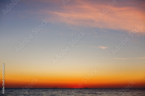 Beautiful view of sunrise in sea. Yellow and pink sky and waves in sea landscape. Sunset  dusk or dawn horizon in ocean. Summer vacation on tropical island