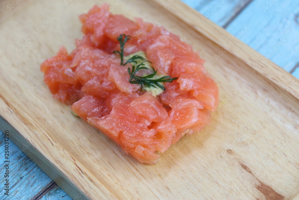Tartare de saumon sur un plateau en bois