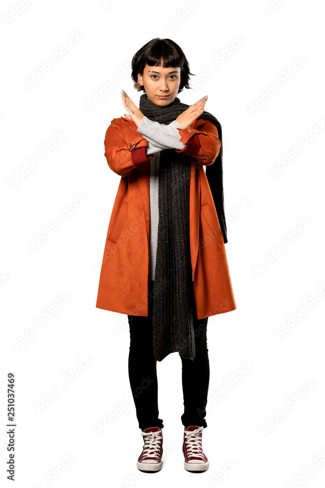A full-length shot of a Short hair woman with coat making NO gesture over isolated white background