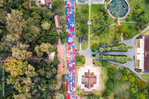 (view from above) Stunning aerial view of the beautiful Haw Pha Bang Temple and the Royal Palace National Museum with colored night market tents on the Sisavangvong Road in Luang Prabang, Laos. photo