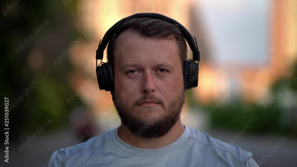 bearded funny man puts on their clothes, turns on music, listens to energetic music, dances. Close-up bearded funny man puts on their clothes, turns on music, listens to energetic music, dances. Close-up