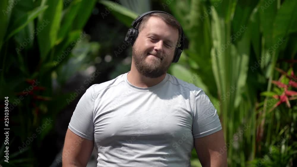 bearded funny man puts on their clothes, turns on music, listens to energetic music, dances. Close-up bearded funny man puts on their clothes, turns on music, listens to energetic music, dances. Close-up