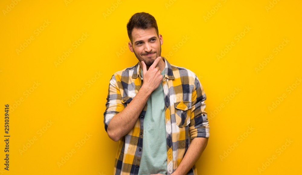 Handsome man over yellow wall thinking Handsome man over yellow wall thinking
