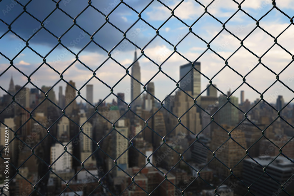 New York city behind steel mesh wire fence. Concept New York city behind steel mesh wire fence. Concept