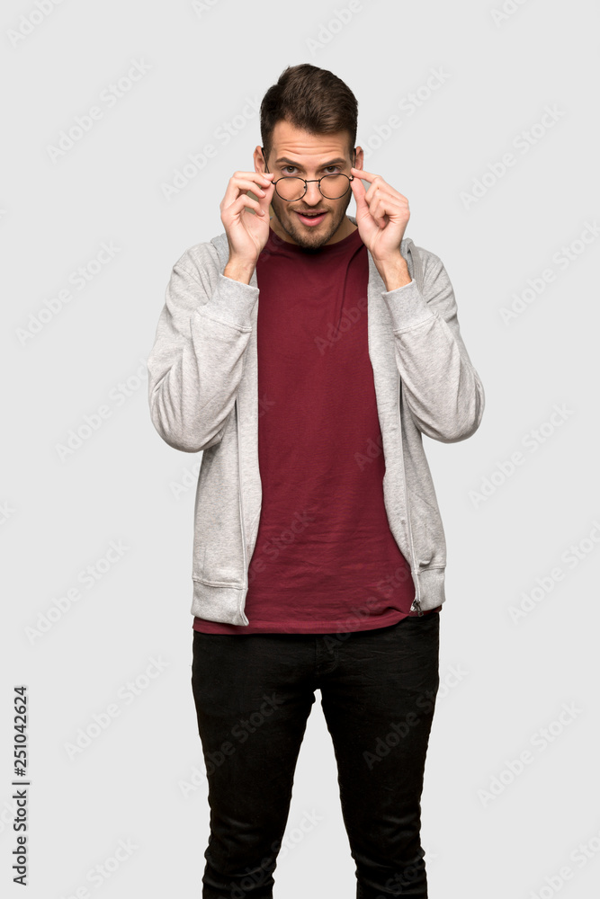 Man with sweatshirt with glasses and surprised over grey background Man with sweatshirt with glasses and surprised over grey background