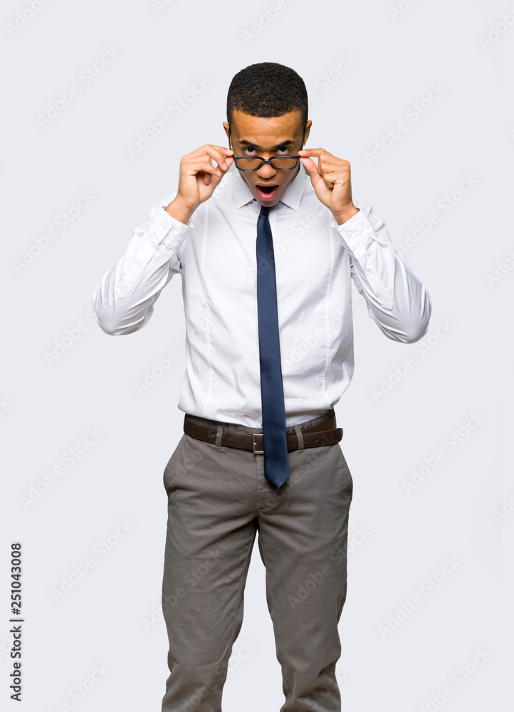 Young afro american businessman with glasses and surprised on isolated background Young afro american businessman with glasses and surprised on isolated background