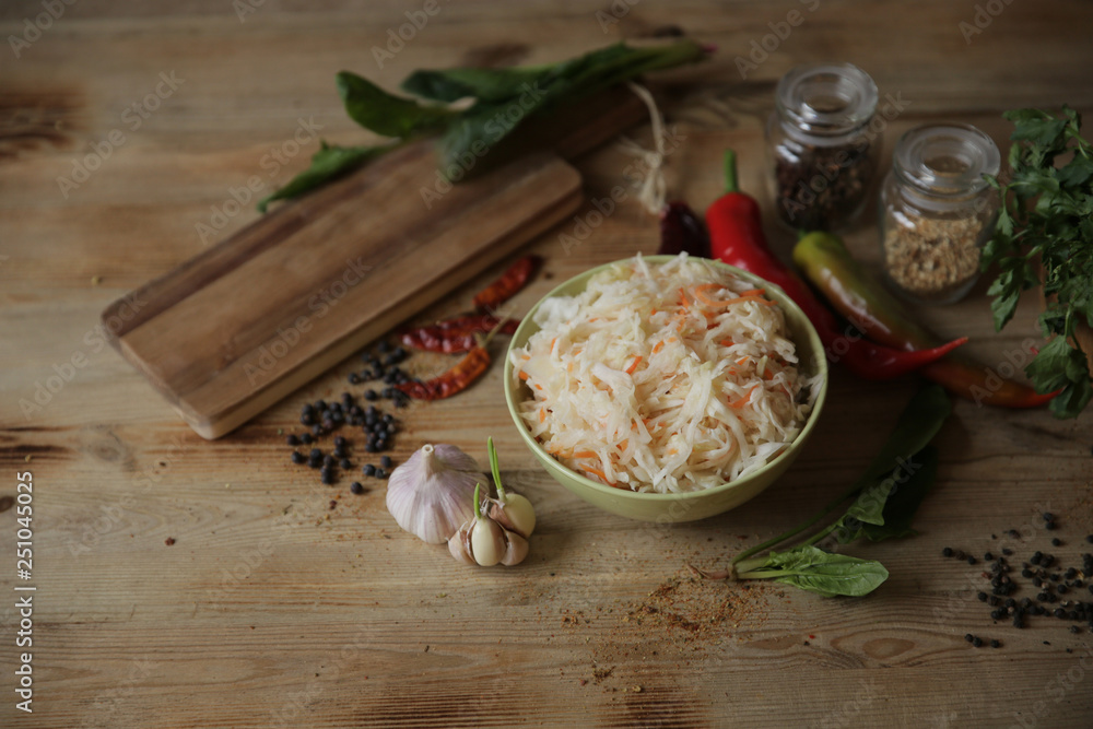 sauerkraut in a bowl on a wooden table with spices and herbs with copy space for text sauerkraut in a bowl on a wooden table with spices and herbs with copy space for text