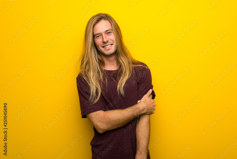 Obraz premium Blond man with long hair over yellow wall With happy expression