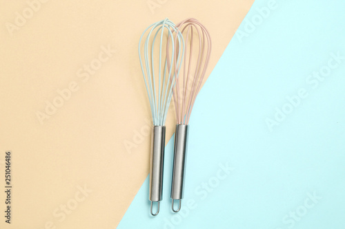 Two whisk on blue pink pastel background. Top view  minimalism.