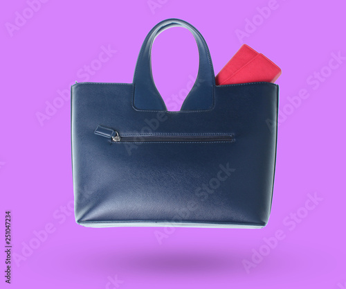 Purse in a leather bag isolated on purple background.