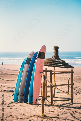 Different colors of surf on a the sandy beach in Casablanca - Morocco. Beautiful view on sandy beach and ocean. Surf boards for renting. Surfer school.