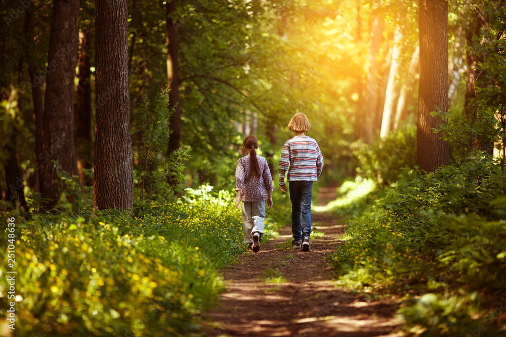 Two children are walking along the path Two children are walking along the path
