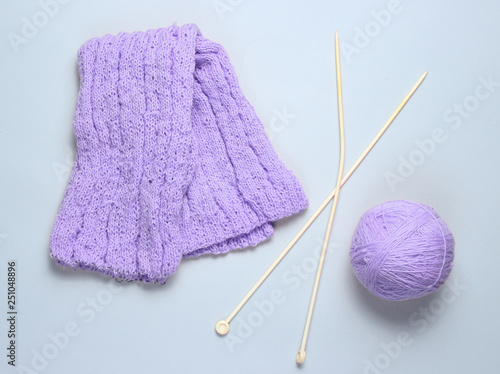 Knitting needles, thread balls, yarn on a gray background..