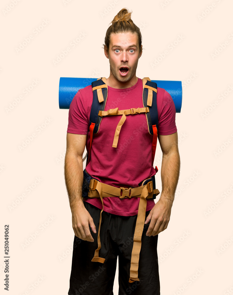 Hiker man with mountain backpacker with surprise and shocked facial expression on isolated background Hiker man with mountain backpacker with surprise and shocked facial expression on isolated background
