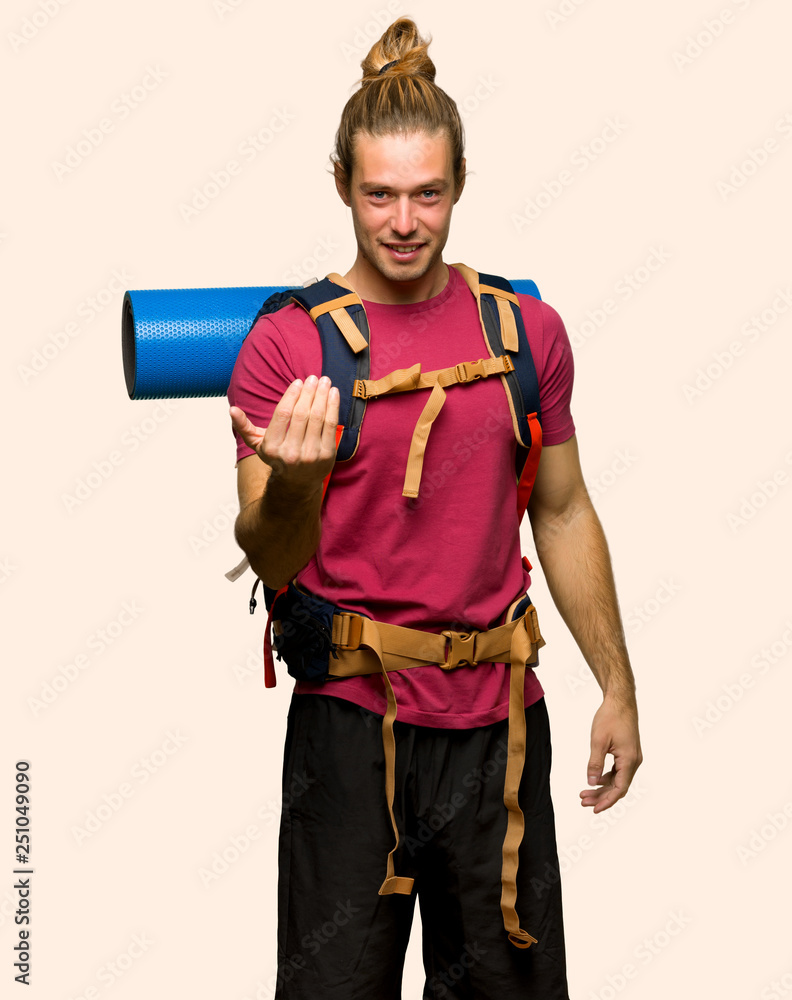 Hiker man with mountain backpacker inviting to come with hand. Happy that you came on isolated background Hiker man with mountain backpacker inviting to come with hand. Happy that you came on isolated background