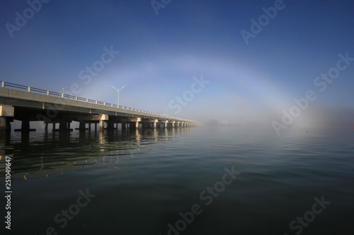 Bright fogbow over the Bear Cut Bridge on a calm foggy morning off Key Biscayne, Florida.
