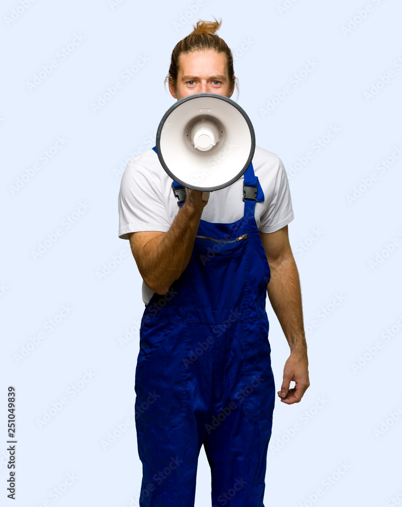 Workman shouting through a megaphone to announce something on isolated background Workman shouting through a megaphone to announce something on isolated background