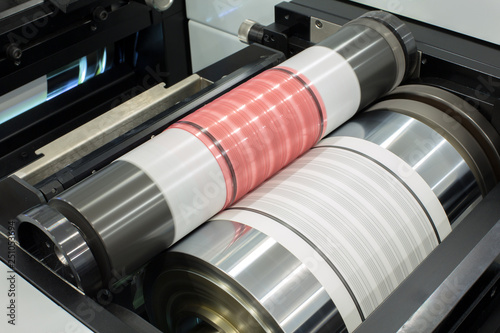 Flexography printing process on in-line press machine. Photopolymer plate stuck on printing cylinder, substrate is sandwiched between the plate and the impression cylinder to transfer the ink. photo