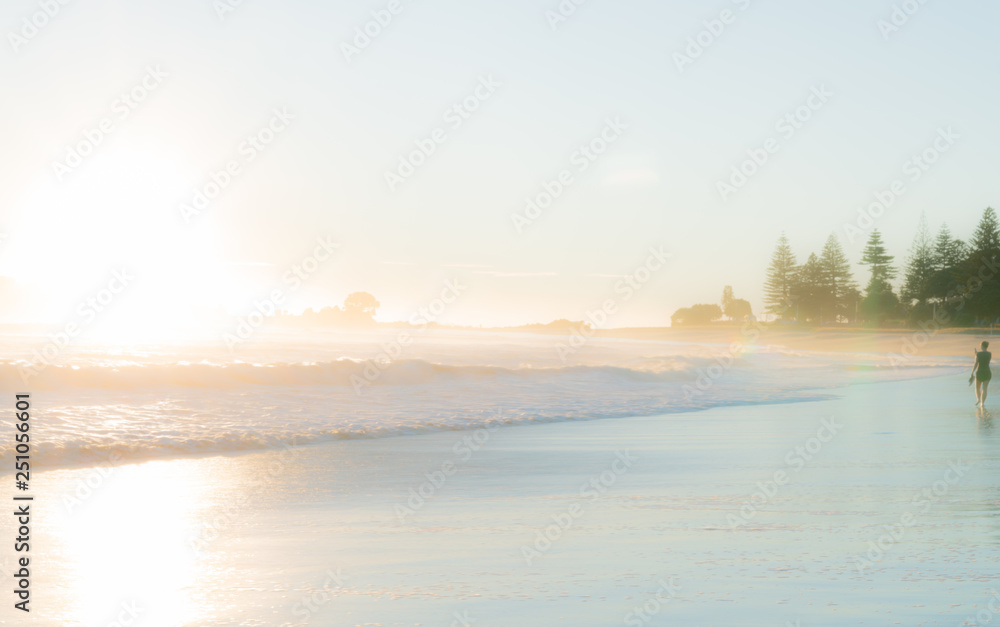 sunrise on beach as waves roll in