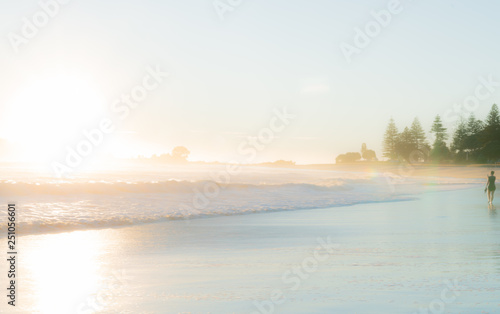 sunrise on beach as waves roll in