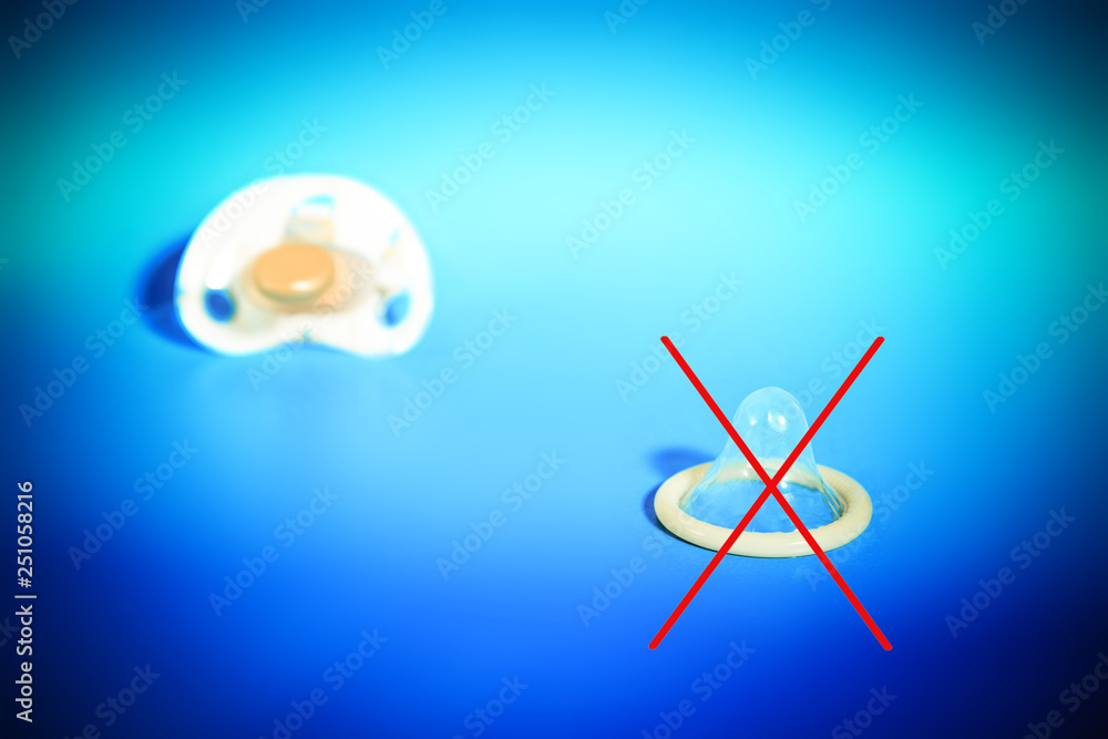 The crossed out condom with a pacifier, the concept of a healthy child, for birth, against - contraception. The crossed out condom with a pacifier, the concept of a healthy child, for birth, against - contraception.